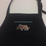logo for hamilton wholesale meats on black apron