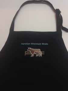 logo for hamilton wholesale meats on black apron