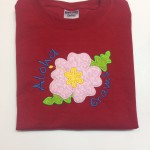 pink hibiscus flower applique on red shirt with aloha and grams personalization