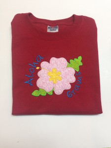 pink hibiscus flower applique on red shirt with aloha and grams personalization